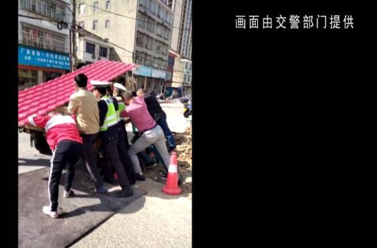 鼎城：三轮车陷路面坑洞 交警路人合力推车解困