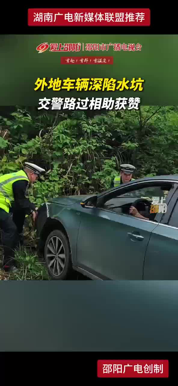 外地车辆深陷水坑 交警路过相助获赞